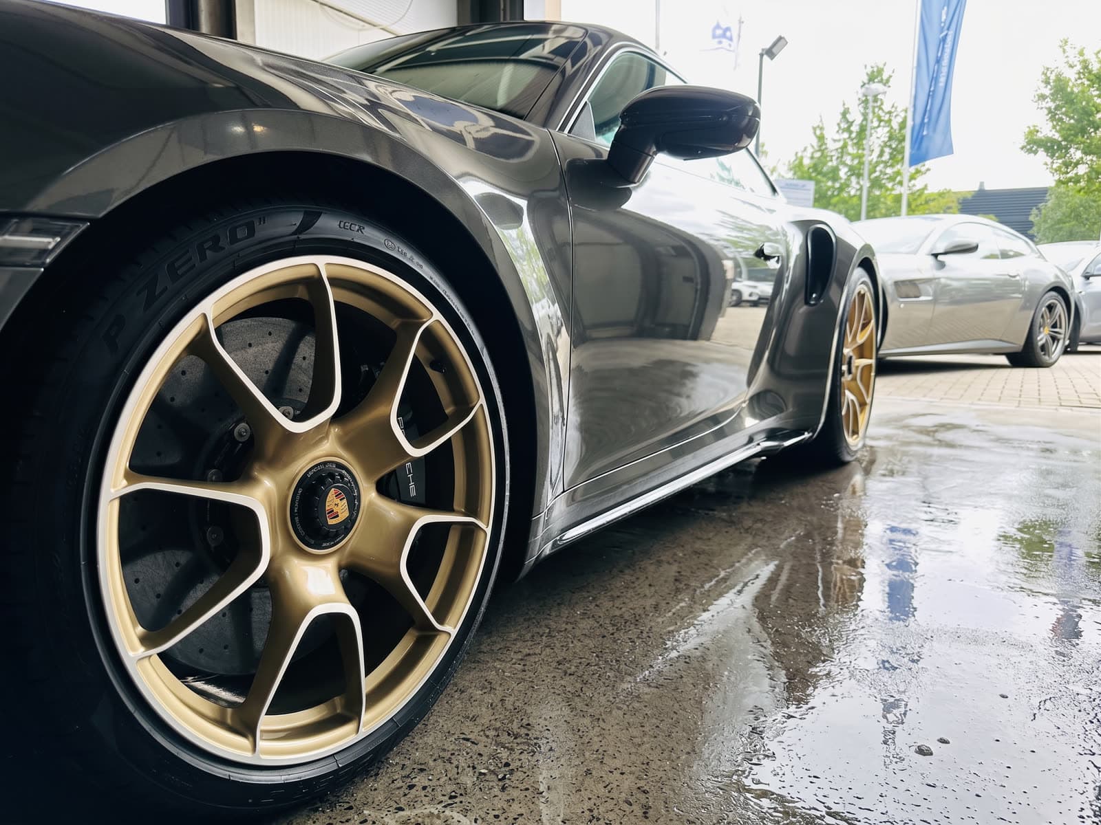 Porsche 992 Turbo S mit Gold-Felgen und Pirelli P Zero vor StarWash
