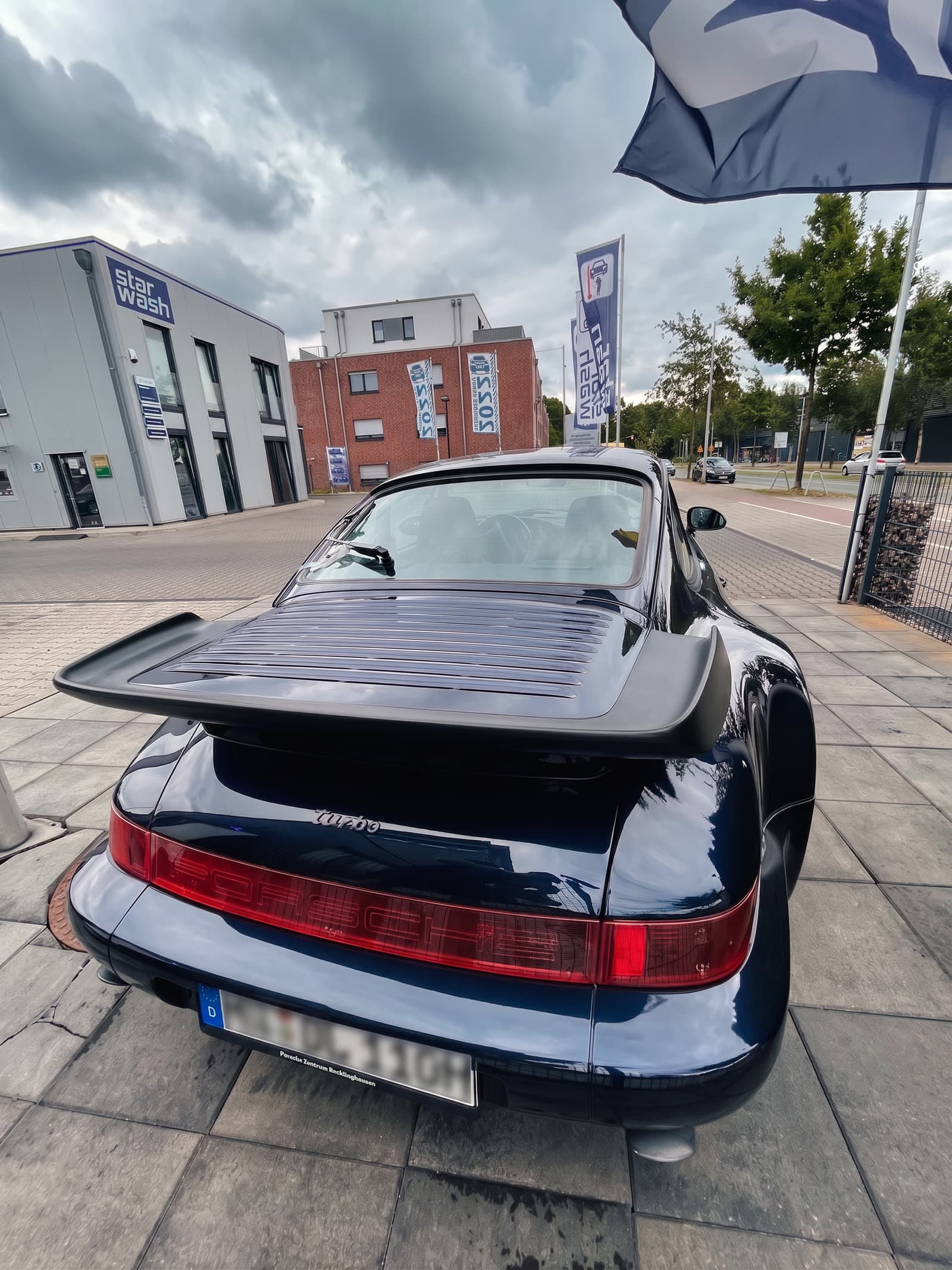Porsche 911 (964) Turbo dunkelblau vor StarWash-Fahne